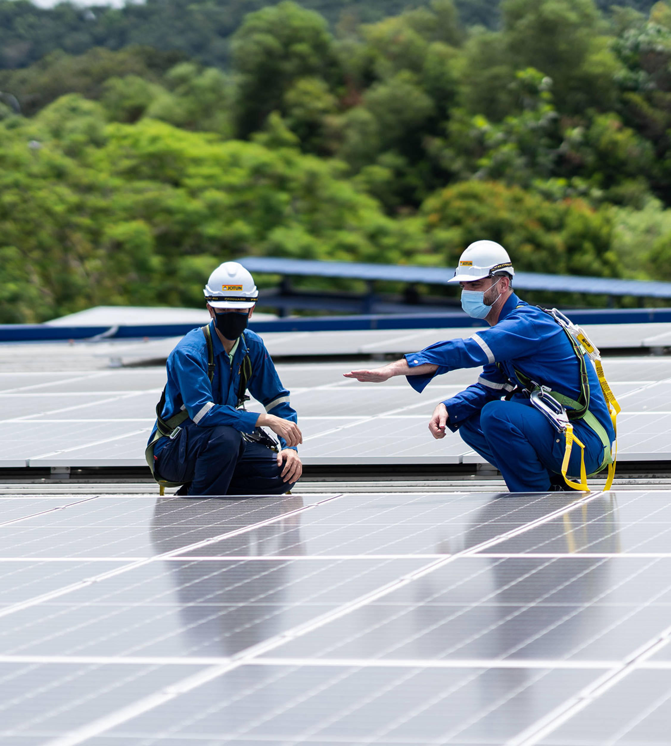 Two employees at the Nilai factory in Malaysia inspecting the solar panels on the roof of the factory