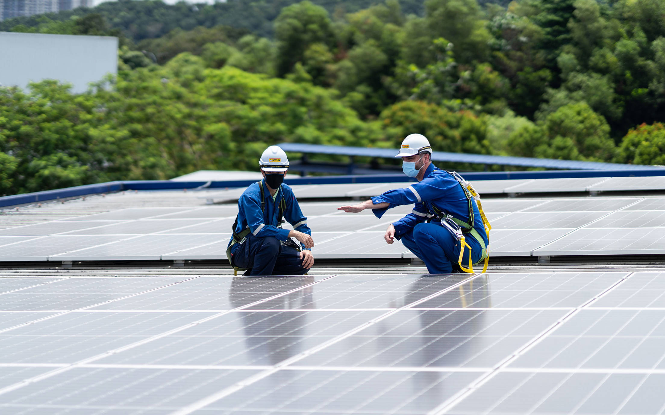 Two employees at the Nilai factory in Malaysia inspecting the solar panels on the roof of the factory