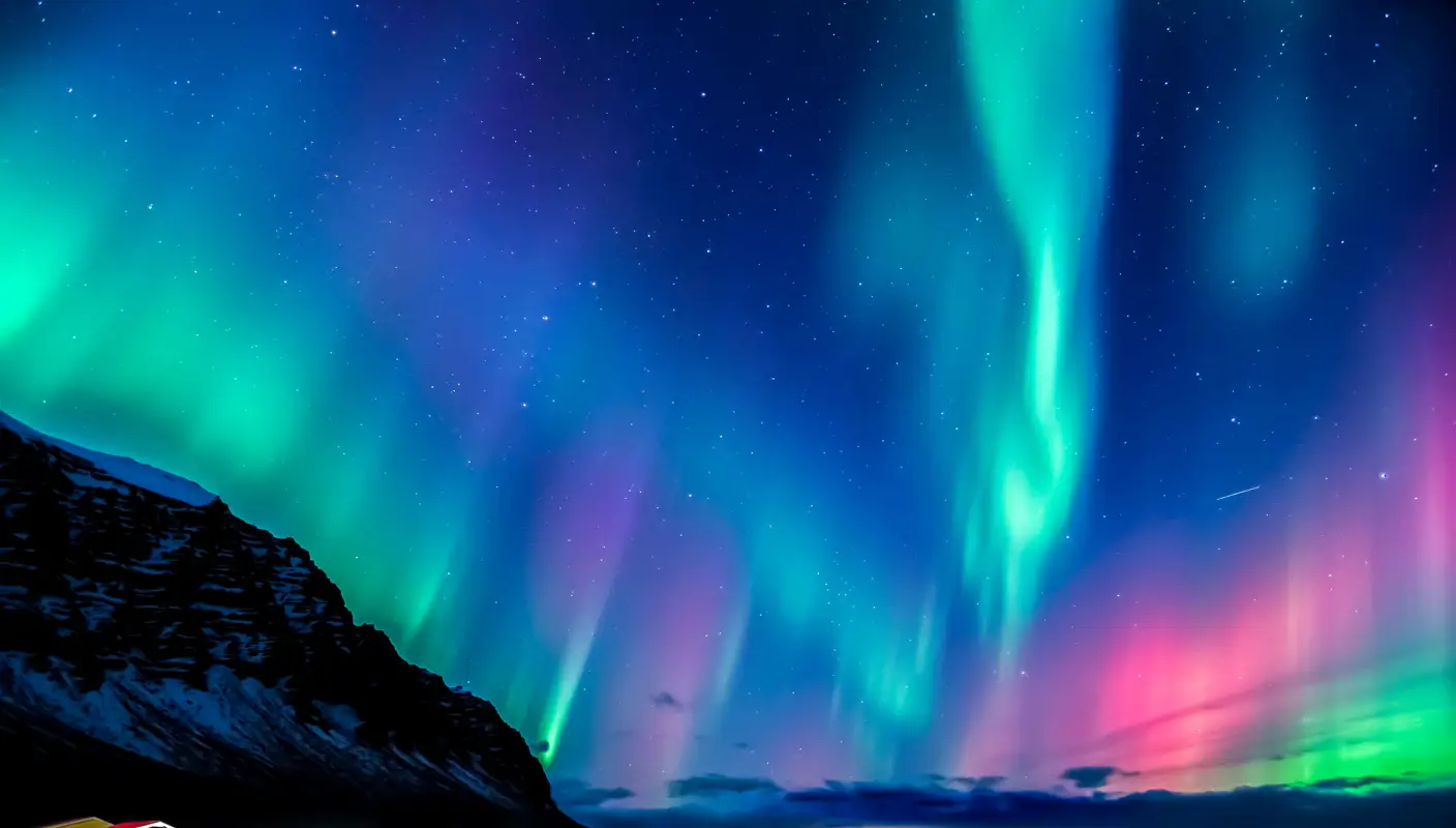 Northern lights over a small village, the ocean and surrounding mountains