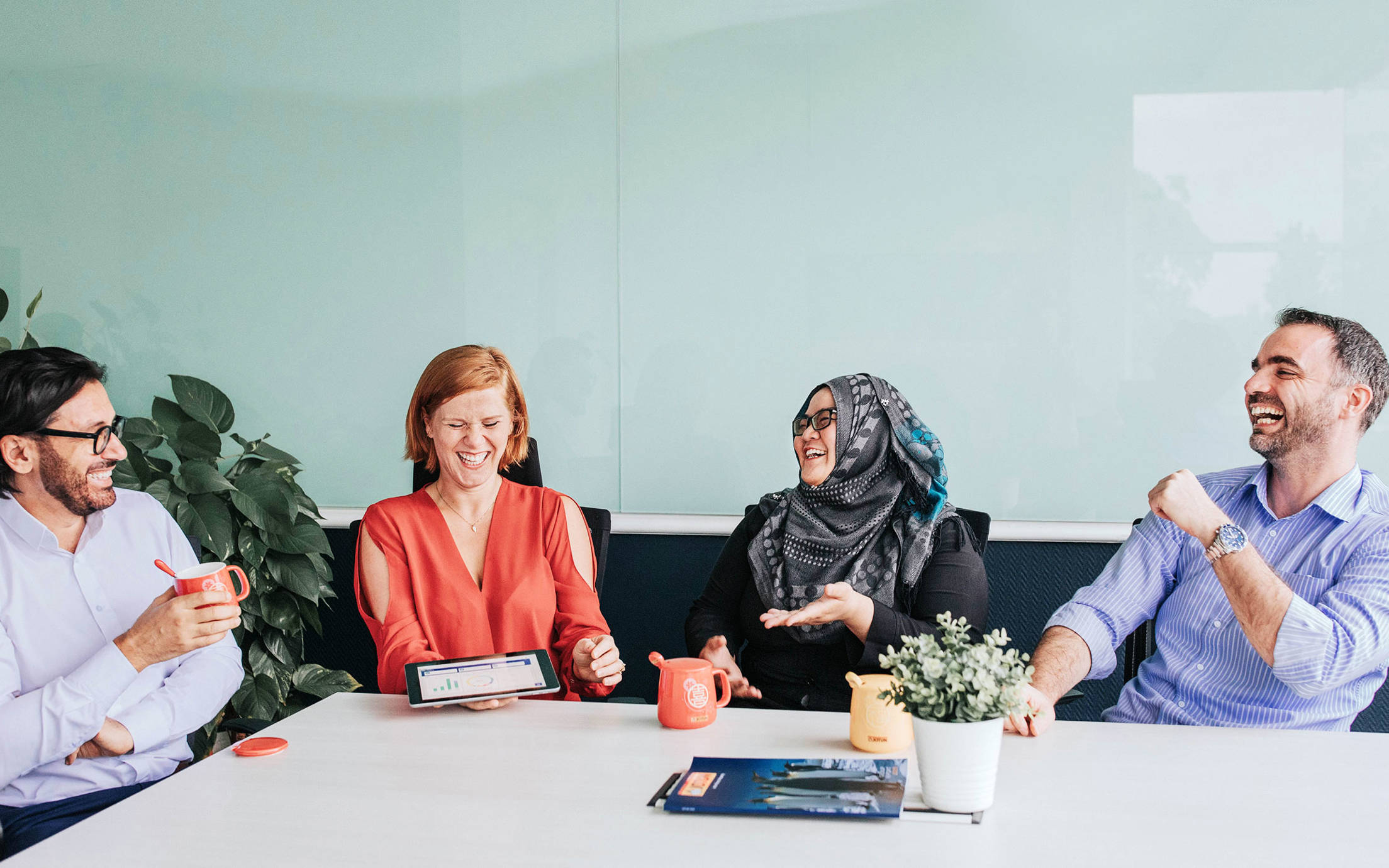 Four people sitting at a table laughing